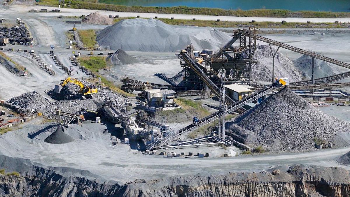 Aerial view of an open aggregate quarry with crushing plant, conveyors and stockpiles